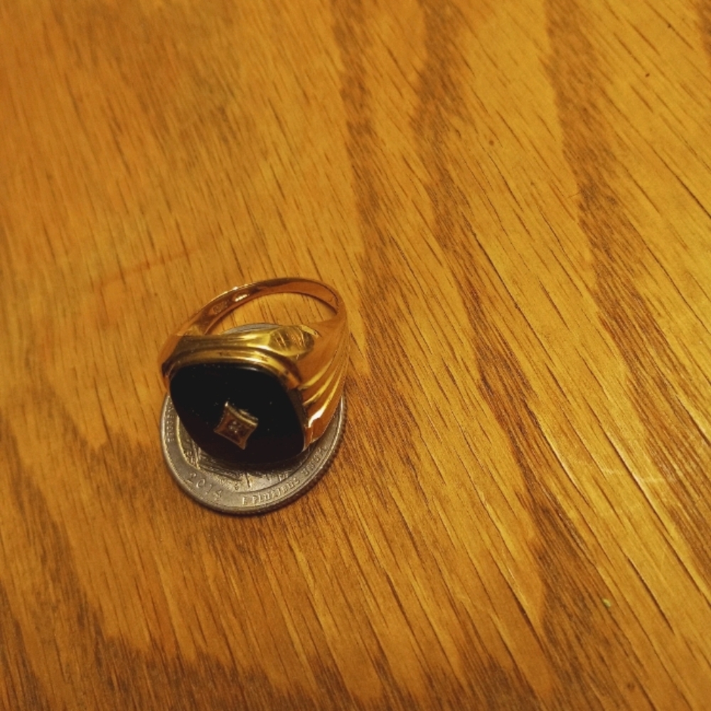 5.7 G gold ring w/onyx stone an diamond in center